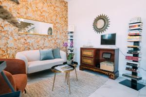 sala de estar con sofá, TV y mesa en L'Hotelet del Delta - adults, en Deltebre