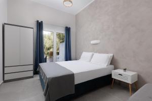 een slaapkamer met een wit bed en een raam bij The Lake Apartments in Kommeno