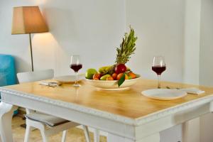 - une table avec un bol de fruits et deux verres de vin dans l'établissement NanSea Apartment, à Loutra Elenis