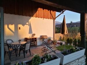 un patio con mesa, sillas y sombrilla en Ferienwohnung Stöckl, en Grabenstätt