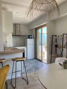 a kitchen with a table and a kitchen with a view of the ocean at Appartement CUBA NICE in Saint-Laurent-du-Var