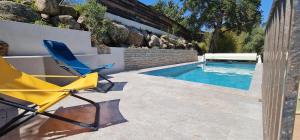 a yellow chair sitting next to a swimming pool at Villa Santa in Porto-Vecchio