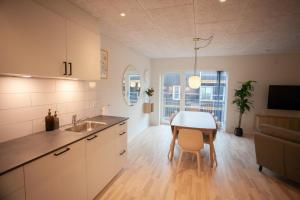 a kitchen with a table and a dining room at New / 4 BR / Cozy / Walks / Hoyvík in Tórshavn