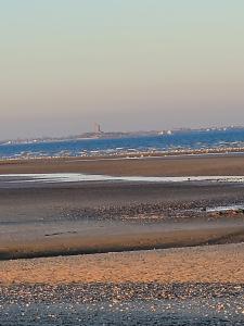 a beach with the ocean in the background at Côté Plage in Saint-Marcouf