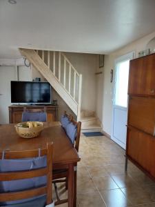 a dining room with a table and a television at Perrot Henry in Saint-Marcouf