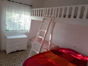 a bedroom with a bunk bed and a ladder at Maison de village au calme - Alonia Village House in Psinthos