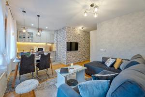 ein Wohnzimmer mit einem blauen Sofa und einer Küche in der Unterkunft Le Sorelle Zlatibor in Zlatibor