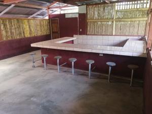 an empty room with a counter with stools around it at Iguanitas Lodge in Pital