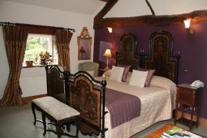 a bedroom with a large bed with purple walls at Ferraris Country House Hotel in Longridge