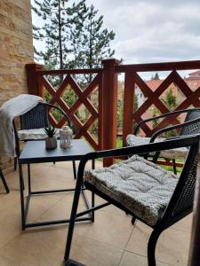 a chair and a table on a balcony with a view at Apartman Sanjalica in Zlatibor