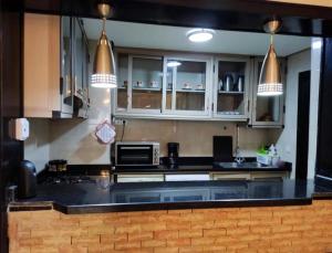 a kitchen with white cabinets and a black counter top at MARINA AGADIR in Agadir