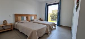 two beds in a room with a window at Villa Giulia in Porto-Vecchio