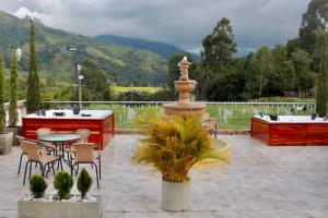 a patio with a fountain and a table and chairs at Hotel Boutique Palmas de Salento in Salento