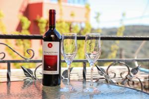 a bottle of wine and two glasses on a table at Casa Del Paese in Avliótai