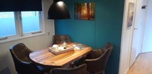 een eetkamer met een houten tafel en stoelen bij Chalet op mooie rustige plek in Enschede