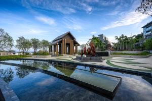 una piscina frente a un edificio con una fuente en Panora Deluxe sea view apartment by Lofty en Surin Beach