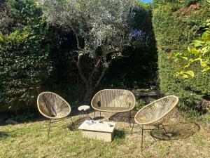 3 Stühle und ein Tisch vor einem Baum in der Unterkunft "A Deux Pas de la Montagnette", mazet provencal 4 personnes in Boulbon