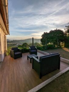 a patio with couches and chairs on a wooden deck at Casa da Mata in Paredes de Coura