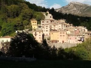 a group of buildings on a hill with a mountain at Les deux pentes in Sausses