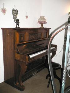 an old piano with a lamp on top of it at Gästehaus Riedl in Warmensteinach