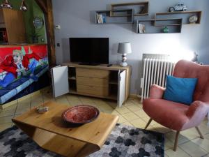 sala de estar con TV, silla y mesa en APPARTEMENTY COCO BOLO, en Bourges