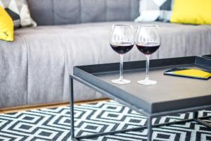 two wine glasses sitting on a table in a living room at DeBlox living - Ibn Gabirol Apartments in Tel Aviv