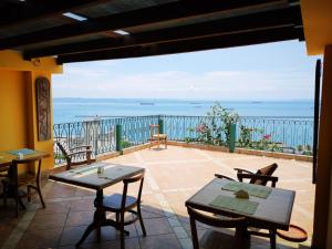 a patio with tables and chairs and a view of the ocean at Pousada do Pilar in Salvador