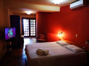 a red bedroom with a bed and a tv at Pousada do Pilar in Salvador
