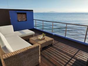 a balcony with a couch and a table on a cruise ship at La Casa Azul in Arkoudi