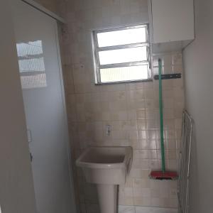Elle comprend une petite salle de bains pourvue d'un lavabo et d'une fenêtre. dans l'établissement Morada do Sol, à Ilha Comprida