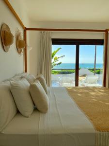 Enjoy Jeri Praia في يريكوكورا: غرفة نوم مع سرير وإطلالة على المحيط