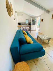 ein blaues Sofa im Wohnzimmer mit einem Tisch in der Unterkunft "A Deux Pas de la Montagnette", mazet provencal 4 personnes in Boulbon