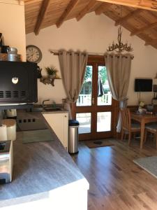 a kitchen with a table and a dining room at Cosy dog friendly lodge with an outdoor bath on the Isle of Wight in Whitwell
