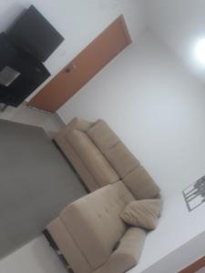 a living room with a couch and a television at Apartamento em Cuiabá in Cuiabá