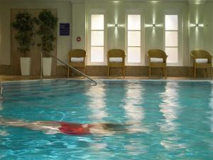 a woman swimming in a pool in a building at Macdonald Bath Spa Hotel in Bath
