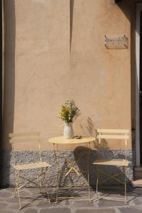 een tafel met twee stoelen en een tafel met bloemen erop bij Sun Garda in Ponti Sul Mincio
