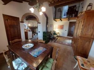 a living room with a wooden table and chairs at Casa di Corte in Scansano