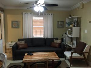 ein Wohnzimmer mit einem schwarzen Sofa und einem Tisch in der Unterkunft Holiday Villas III #311 in Clearwater Beach