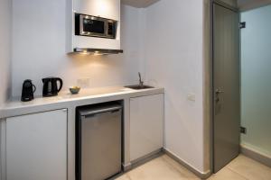 a small kitchen with a sink and a microwave at Seven Suites in Imerovigli