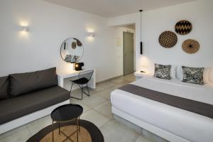 1 dormitorio con 1 cama y 1 sofá en Seven Suites en Imerovigli