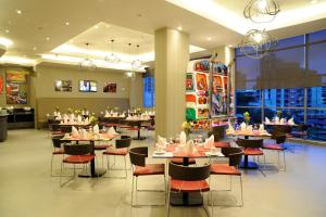 ein Restaurant mit Tischen und Stühlen in einem Raum in der Unterkunft Novotel Panama City in Panama-Stadt
