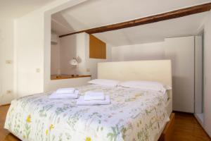フィレンツェにあるVasco Pratolini Apartment di Stefania Sestoのベッドとタオル2枚のある寝室
