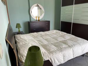 - une chambre avec un lit blanc et un miroir dans l'établissement Sea view apartment/beach/city center/WiFi, à Durrës