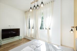 um quarto branco com uma cama e uma televisão em MagnoliaApartments - 18B Visconti Duomo em Milão