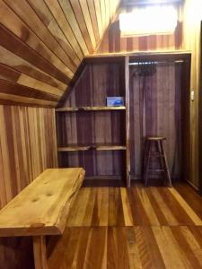 a small room with a wooden table and a stool at Chalé Romântico - Gramado in Gramado +25 photos
