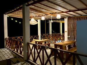 a patio with tables and lights on a balcony at Hostal Casa en la Ciénaga in San Onofre