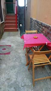una mesa rosa y una silla con un mantel rojo. en Appartamento Severino - Rariche House en Camerota