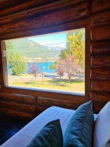 a bedroom with a window with a view of the water at Puerto Lacar Lodge SMARG in San Martín de los Andes