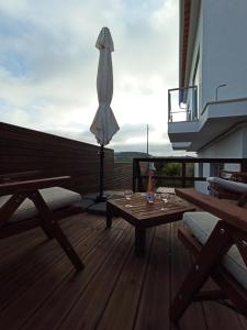 a patio with a table and an umbrella on a balcony at Refúgio da Sancheira Grande in Óbidos
