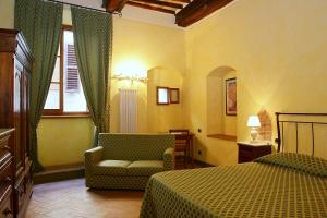 a bedroom with a bed and a chair and a window at La Locanda di Quercecchio in San Gimignano